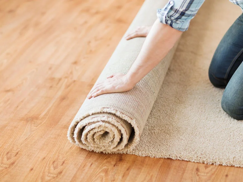 Woman rolling up carpet