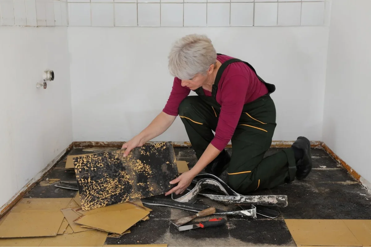 Woman removing vinyl flooring